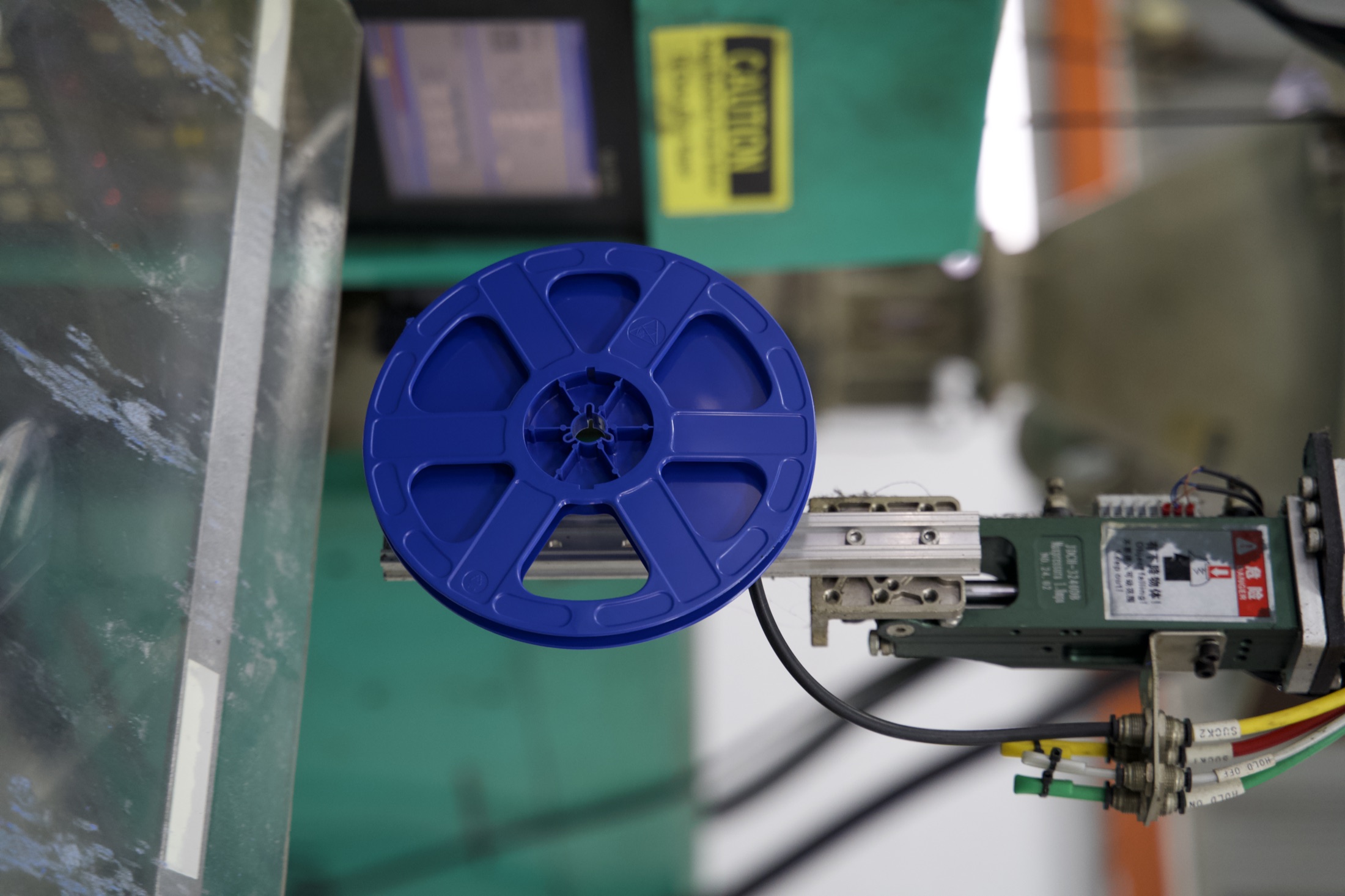 Blue Taipex molded reel held by automated production handling equipment